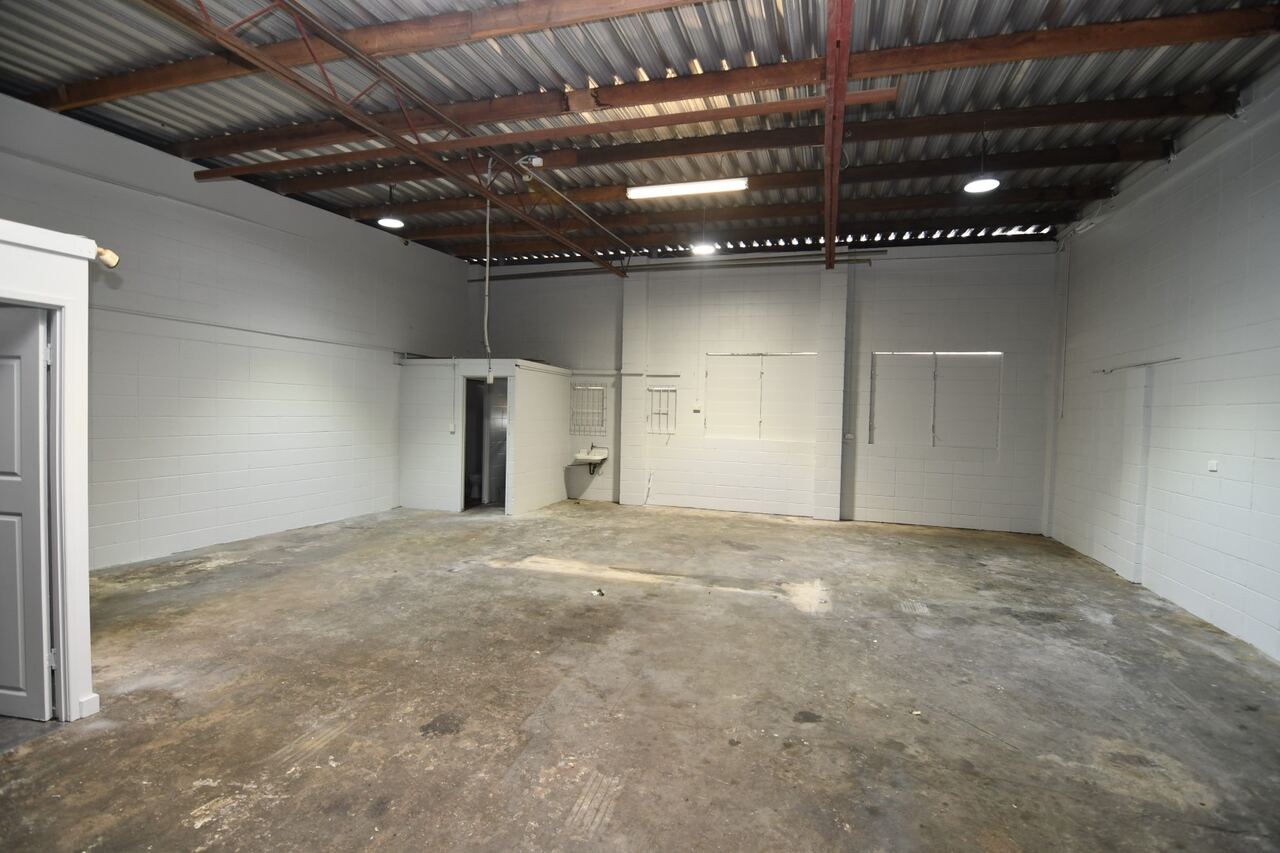 Warehouse interior — open floor with high roof and enclosed office at rear