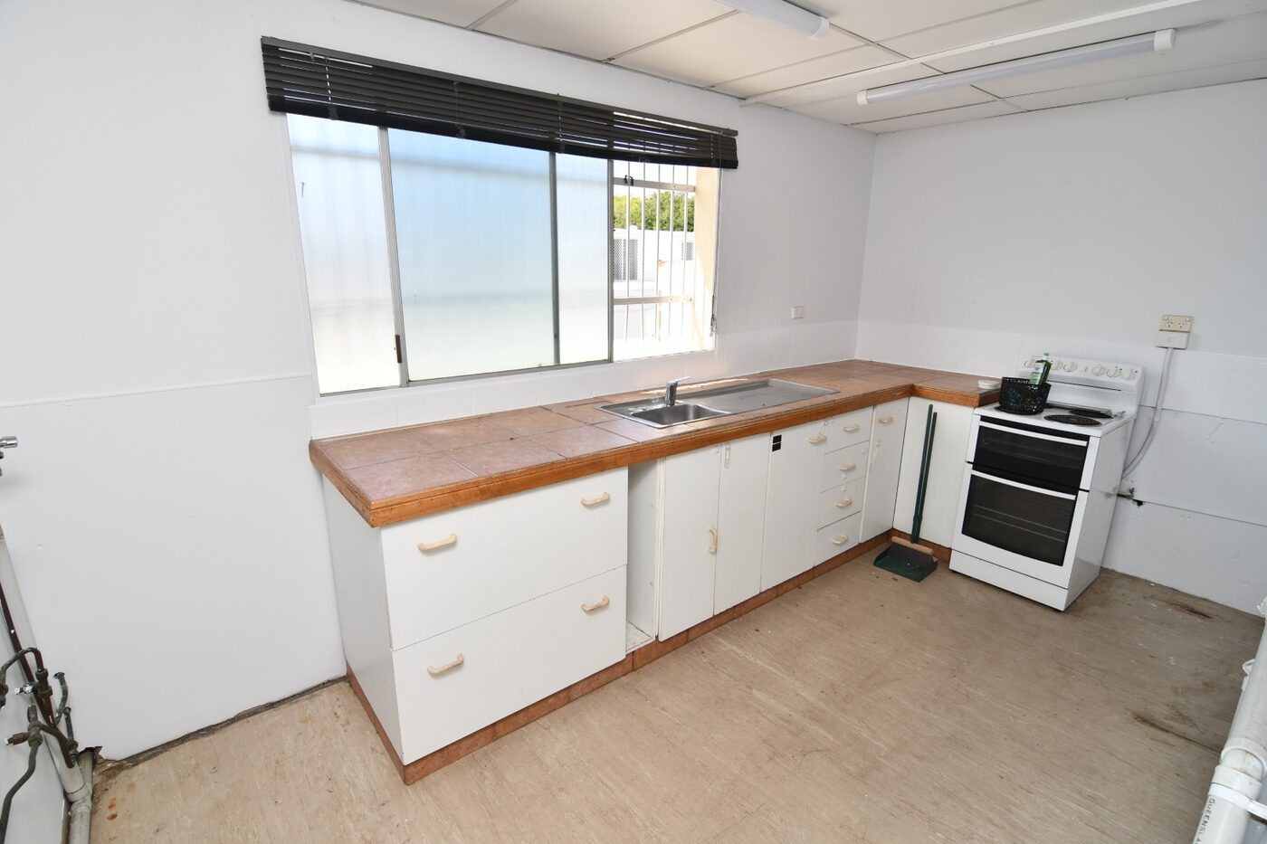 Full kitchen with sink, oven, cooktop and window