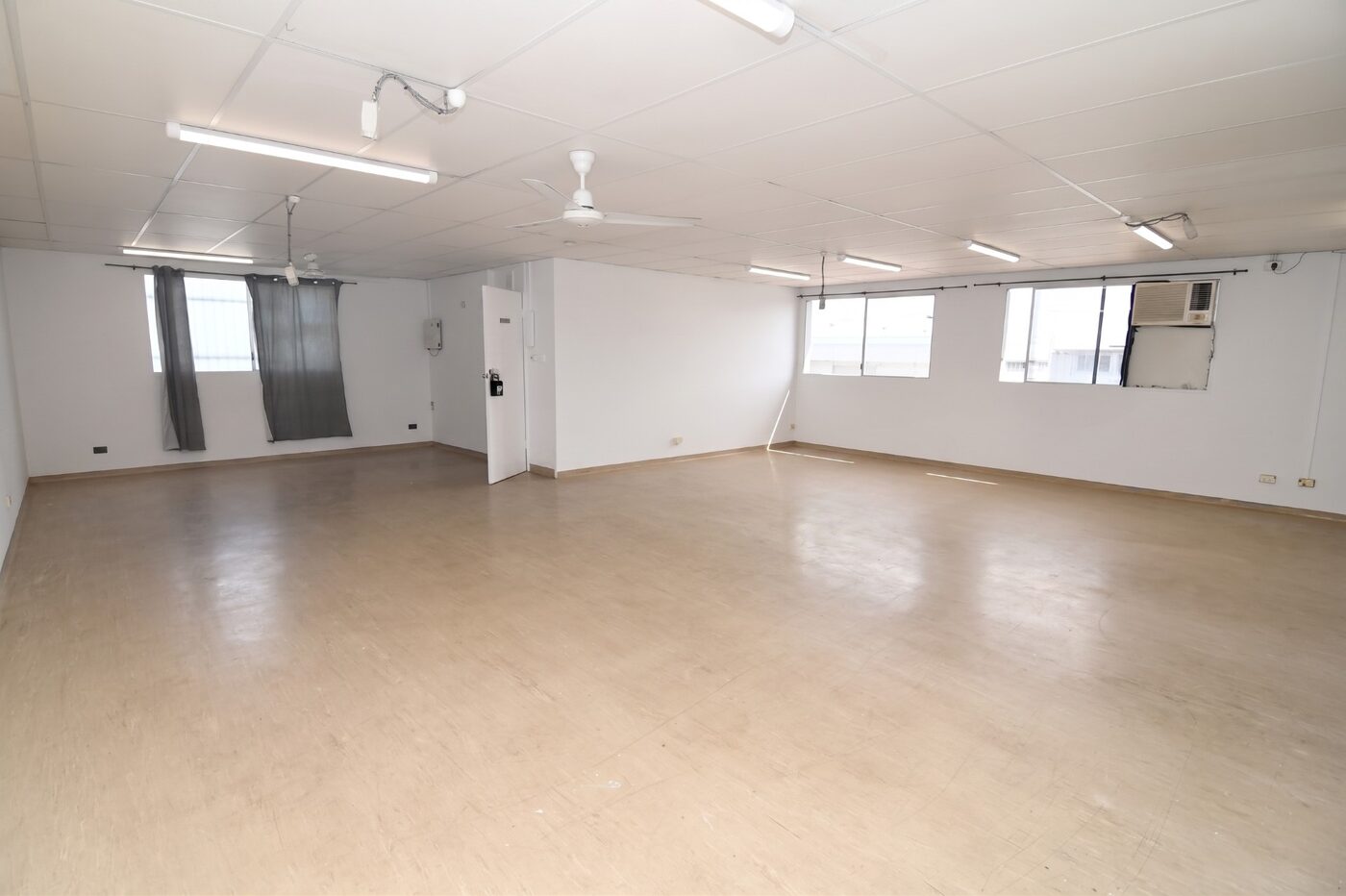 Open-plan office space with air conditioning, ceiling fans and windows
